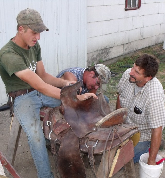Caleb, Clayton and Fred fixing a saddle.
