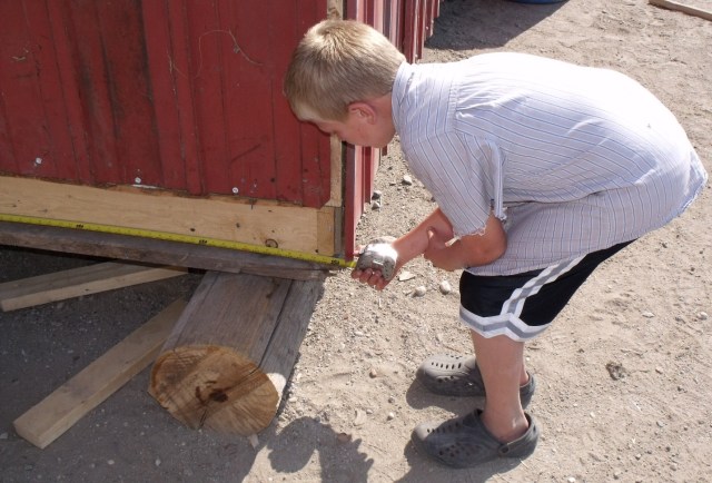 Mario checks measurements on new chicken house.
