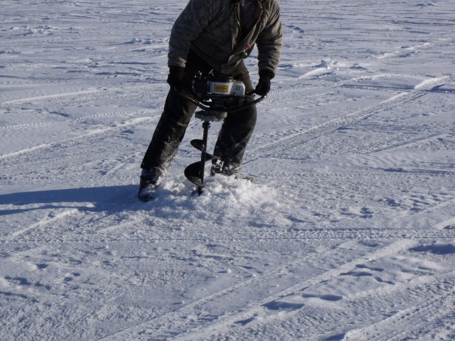 In order to catch the fish we need to dig down through 14 inches of ice.  He makes it look easy.