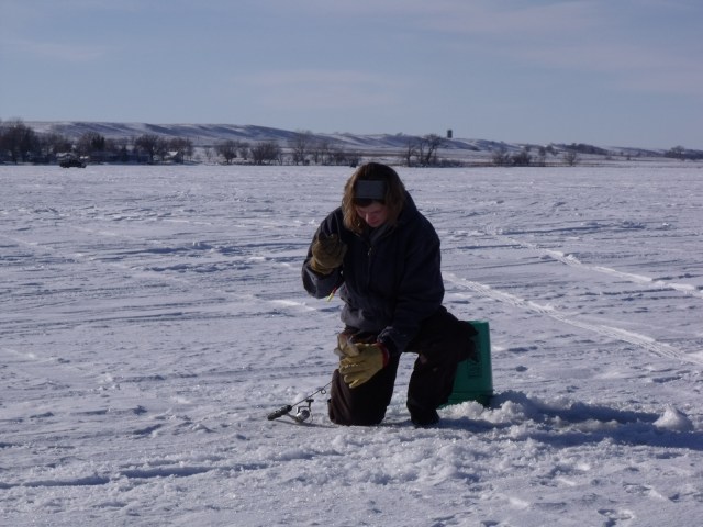 Silvana pulls up a fish and is about to pull it off of the hook.  Notice the lovely back ground view.  Peaceful and lovely!!