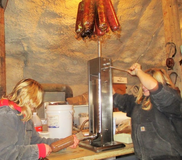 Silvana and Marisa stuffing sausages. On top hanging are some of the smoked sausages.